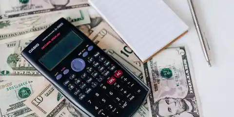 Calculator and notepad on a desk, working out event costs