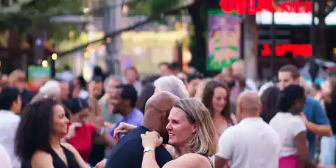 Crowd salsa dancing outdoors on a summer day