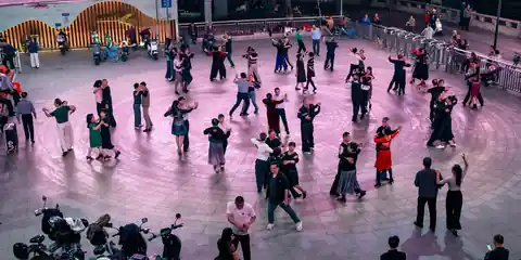 Large group dancing at an evening Latin social under purple lights