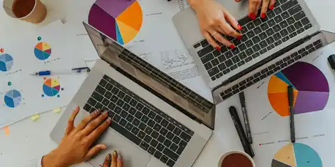 Team comparing charts and laptops during a software evaluation