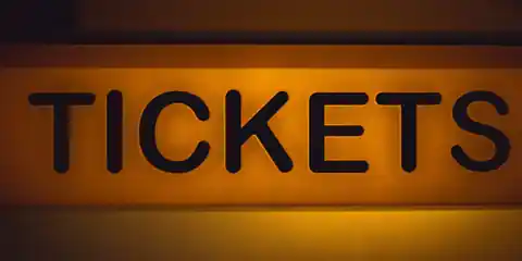 Illuminated ticket sign glowing against a dark background